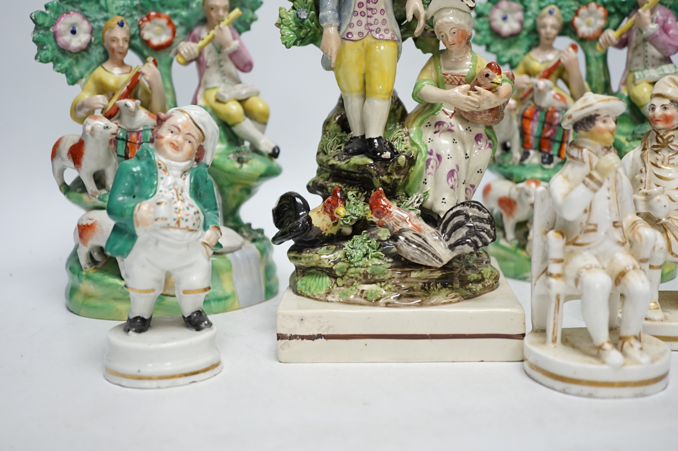 A Staffordshire pottery group of two figures with chickens, c.1800-10, a pair of early 20th century Staffordshire pottery figure groups and three small character figures, tallest 25cm high (6)